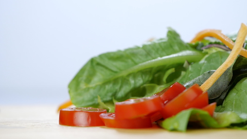 Sliced tomato falling to chopping board in slow motion