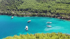 yachts anchored at a green Mediterranean coast, drone
