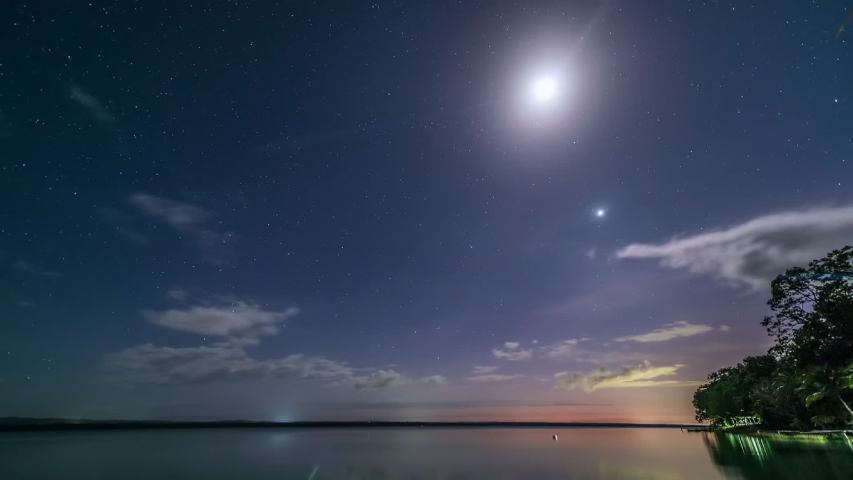 Time lapse of the Milky Way in motion with clouds, moon and stars on top of Itza lake in Peten, Guatemala. 