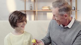 grandfather and grandson laughing while putting building blocks on eyes