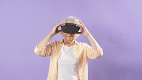 Slow motion old grandmother wearing virtual reality headset and having fun dancing in vr glasses