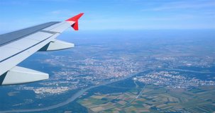 Airplane flying over Bratislava, Slovakia with a view of the wing tip, as seen from a window seat. - Powered by Shutterstock - Get 15% off with code: PIKWIZARD15