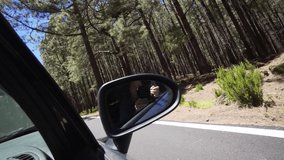 Girl blogger shoot video of herself in the reflection of mirror of a car, in motion.