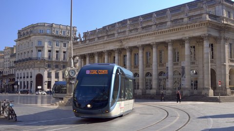 Bordeaux, France - July 2019 : Tram passing in front of the Grand Theatre facade, famous Opera and Ballet house of Bordeaux on Place de la Comedie