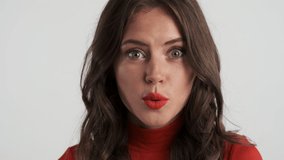 Portrait of pretty brunette girl fooling around on camera over gray background. Fish expression