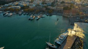 Aerial birds eye view drone video of Rhodes city island, Dodecanese, Greece. Panorama with Mandraki port, lagoon and clear blue water. Famous tourist destination in South Europe.