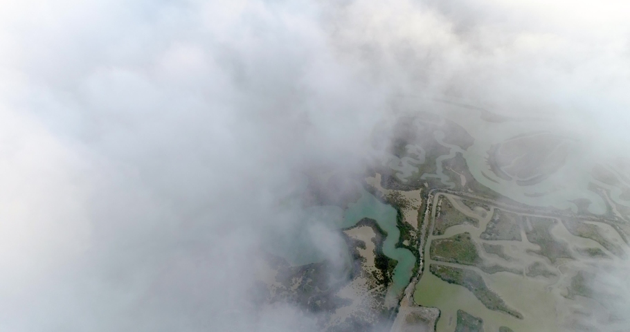 aerial view, flying over clouds on salt marshes where seawater is processed to produce sea salt, a wonderful natural food and an important product.