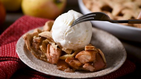 American apple pie with ice cream. Eating pie with fork. Take a bite of tasty sweet pie closeup view