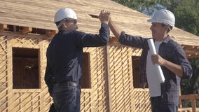 teamwork handshake. concept building constructing architect slow motion video. two men builder in helmets shake hands contract business contrast at a construction site. lifestyle two workers in