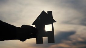 happy family construction house concept. lifestyle man holding home a paper house in his hands at sunset silhouette sunlight. life ecology video symbol
