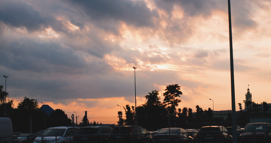 Picture of the many nice cars at the parking lot outside under the very beautiful and picturesque sky at the sunset. Blue and pink skyline.