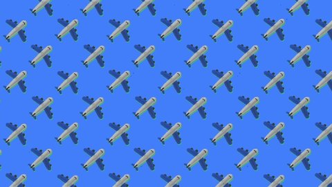 A pleasant animation made from a repeated pattern: an airplane,ing to the upper left angle, over a blue background.
