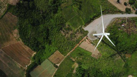 Aerial top view of windmills rotating by the force of the wind for generating clean renewable energy for sustainable development in a green ecologic way at highland. Bird’s eye view shot by drone.