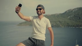 Selfie On Mobile Phone In Beautiful Place In Turkey Trip. Man Taking Self Photo And Answer To Video Call Sea Cliff. Guy Takes Pictures On Smartphone On Seashore. Man Taking Selfie On Holiday Vacation