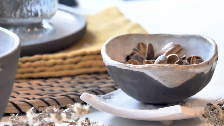 The small bowl with the cereals inside on top of the table inside the dining area