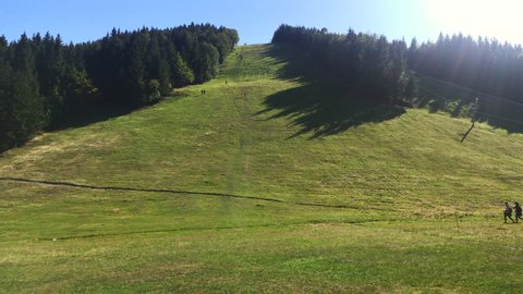 Group of people hiking. Hikers walking down the hill. Outdoor recreation activity. Summer holiday vacation tourism. Tourist silhouettes walking. Slovak ski resort in Sachticky, Slovakia in summer.