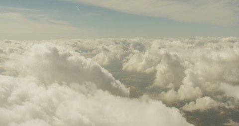Aerial shot, day, slow pan to right examing top layer of clouds, drone
