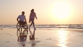 Handicapped man in wheelchair and his girlfriend on a beach at sunset - Powered by Shutterstock - Get 15% off with code: PIKWIZARD15