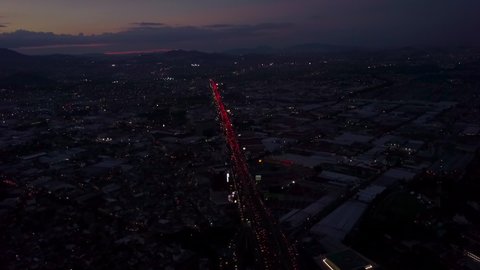 Panoramic aerial view over the huge Manuel Avila Camacho avenue full of vehicles with a beautiful sunset in the background