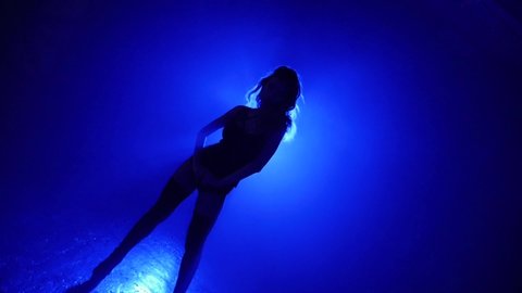 Smoky dark studio, silhouette girl pj is dancing in leather underwear