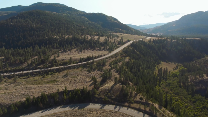 Aerial View of a Scenic Road in the Dry Canadian Mountain Landscape during a sunny summer day. Taken in Okanagan, near Penticton, British Columbia, Canada.