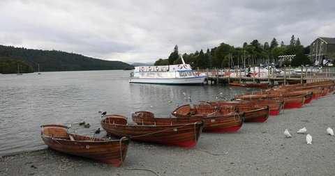 WINDERMERE, ENGLAND - 8 SEP 2018:  Lake Windermere England row boats ferry tour marina. Historic vacation rural community. Northern England in Lake District National Park. Destination for families.