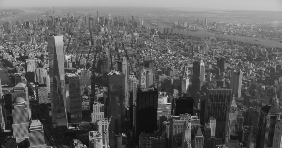 Black and white aerial shot, pan over financial district to Brooklyn Bridge, drone