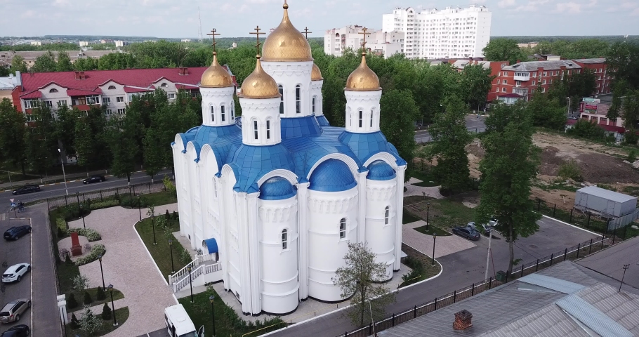 View from drone of Voskresensk cityscape with golden domes of Church of Icon of Our Lady of Jerusalem on spring day, Russia