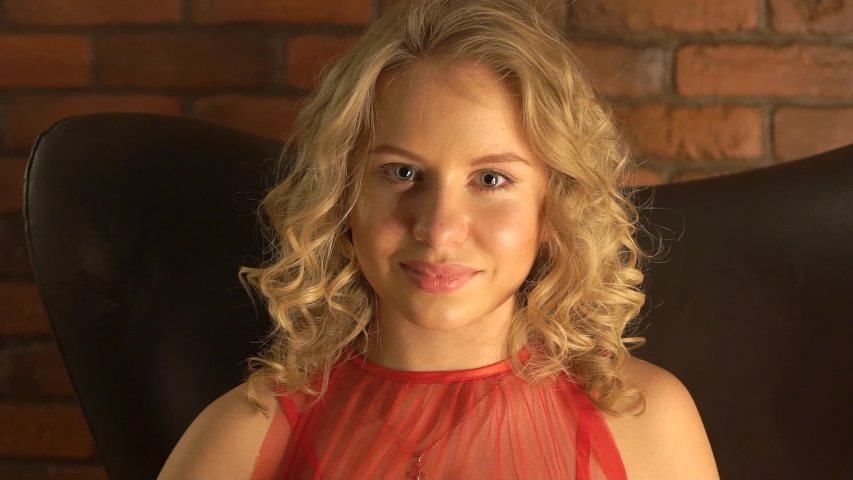 Woman Sitting In Chair Smiling.