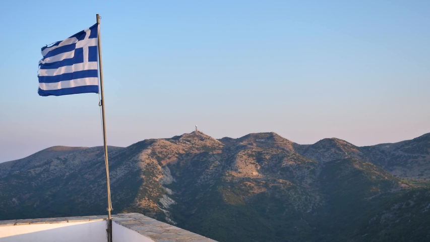 greek flag in wind with mountins 