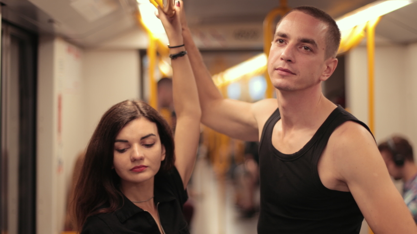 transport. two young people riding the subway, close-up, slow motion