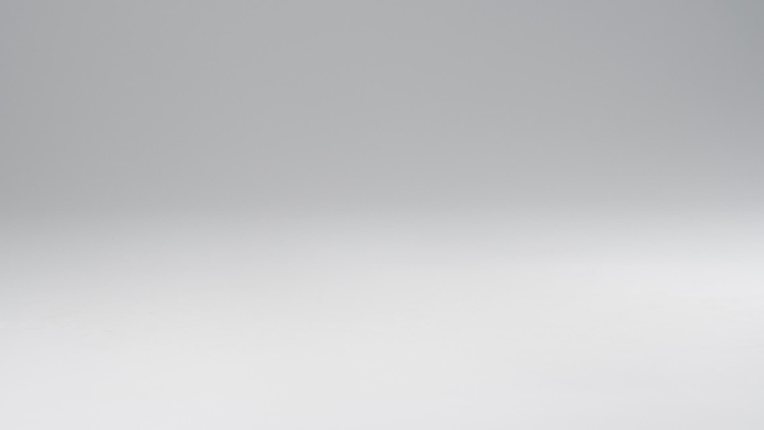 Healthy trail mix falling onto a white surface in slow motion