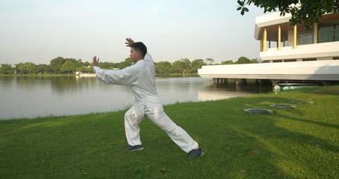 Asian man working out with Tai Chi in the morning at the park, Chinese martial arts, healthy care for life concept part9.