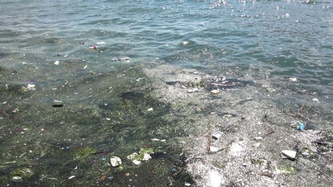 Trash and garbage floating on the surface of the water. Water pollution with dirt and plastic garbage floating on the surface of the sea 