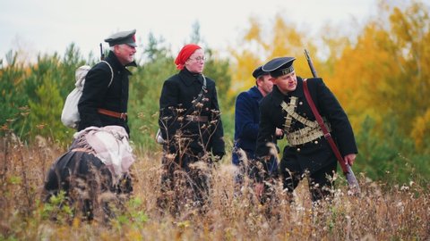 RUSSIA, REPUBLIC OF TATARSTAN 30-09-2019: A reconstruction of military operations in Russia in 1917 - women and men in military clothes standing in the field and looking at something