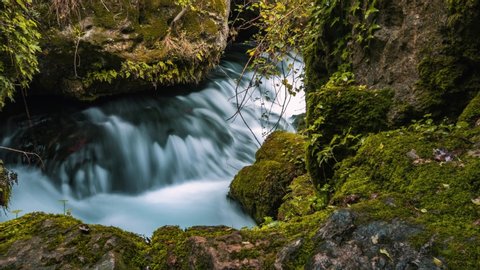 Time lapse of fiver flowing on mossy rocks, sliding shot with long exposure shutter