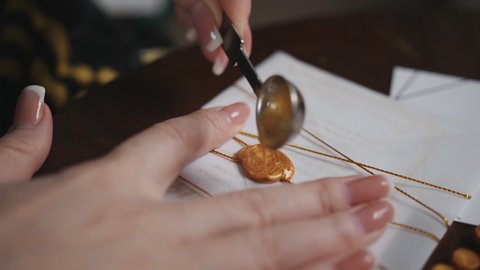 Stamping Gold Wax Seal onto a white Envelope