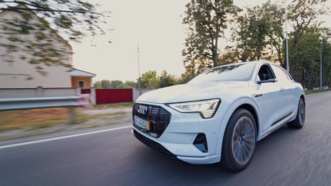 VINNITSA, UKRAINE - September 2019: Front view of a luxury car moving on the road in daylight. New electric car audi e-tron driving on the highway in summer.
