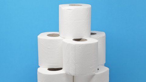 Stack of toilet paper rolls rotating against a blue background