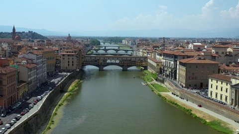 Aerial view flying over the Arno River towards the Ponte Vecchio or Old Bridge, Florence, Italy