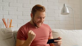 Sports Fan Reaction Concept - Excited sports fan watching his favourite team/player on smart phone, 4k - Powered by Shutterstock - Get 15% off with code: PIKWIZARD15