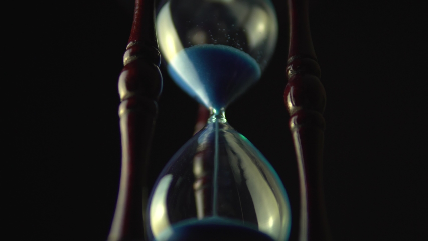Sand move through hour glass. Close up of hourglass clock. Old time classic sandglass timer. Closeup sand is flowing down the bottom. Royalty-Free Stock Footage #1038489950