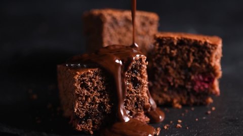 Chocolate pouring on cake. Brownies with chocolate icing on black slate
