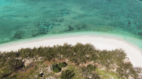 Aerial: Close up shot of Tropical island and reef near Nosy Be, Madagascar.