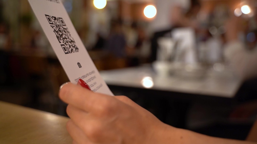 Scanning QR code with smart phone. The woman reads the bar code using the application on the smartphone in cafe Royalty-Free Stock Footage #1038521075