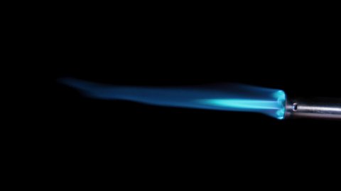 Butane gas burner flame burning from nozzle against black background. Welding tool with burner flame. Blue and Orange Flame from a butane blow torch. Closeup of butane burner.