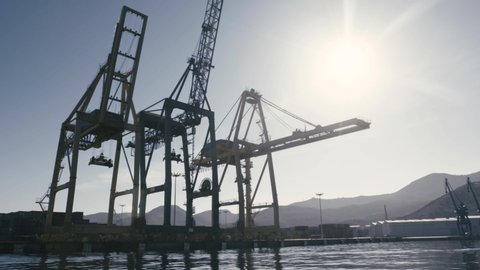 Port Cranes. Dolly from a boat. Lens flare