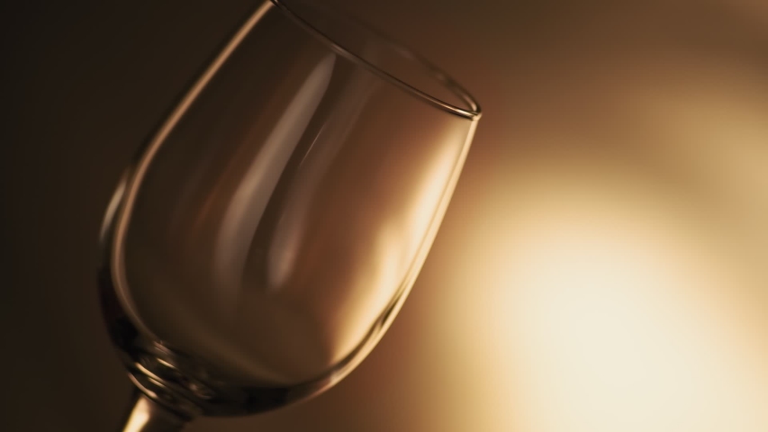 Close-up of filling wine glass with red wine in super slow motion. Pouring red wine into goblet. Red wine forms beautiful wave in glass Royalty-Free Stock Footage #1038544145