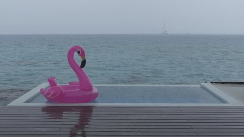 Rain on Vacation - funny video of flamingo float in luxury pool while raining and bad weather on holidays getaway travel.
