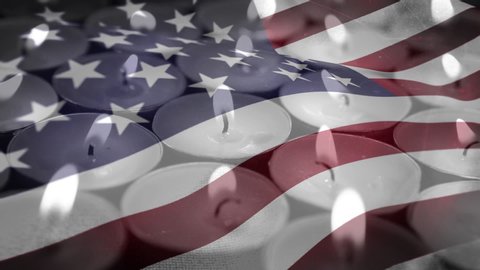 Animation of lit candles burning with a US flag billowing in the background